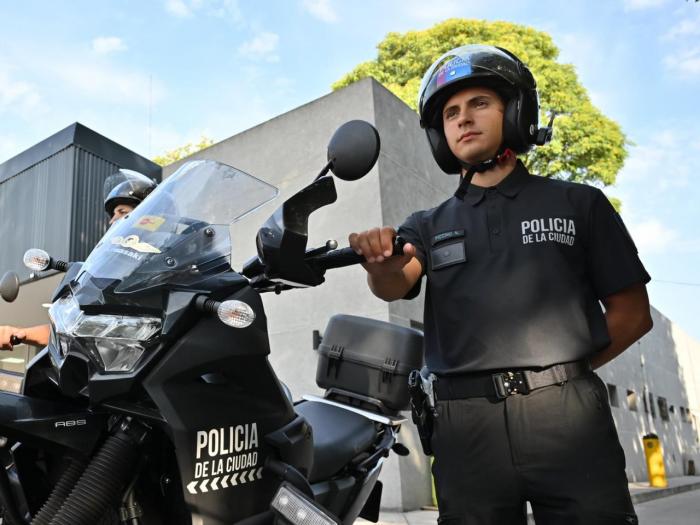 Control policial con un agente de la Policía de la Ciudad junto a una moto policial en la vía pública.
